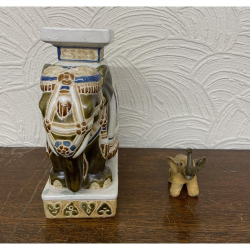 402 - X2 ELEPHANT FIGURINES - ONE CARVED WOODEN ELEPHANT AND ONE ORNATE CERAMIC BLUE, WHITE AND RED STANDI... 