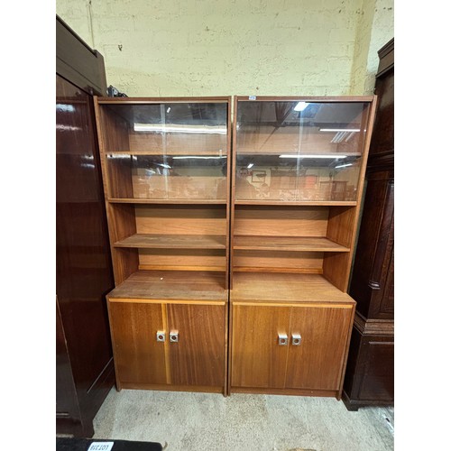 358 - PAIR OF TEAK SLIDING DOOR FOUR SHELF BOOK CASES WITH CUPBOARD BASE