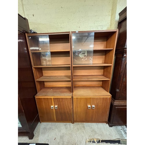 358 - PAIR OF TEAK SLIDING DOOR FOUR SHELF BOOK CASES WITH CUPBOARD BASE