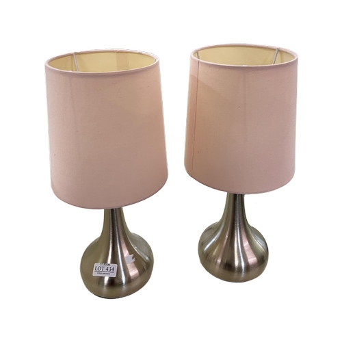 434 - A PAIR OF DUNELM CHROMED TOUCH BEDSIDE LAMPS WITH PINK SHADES