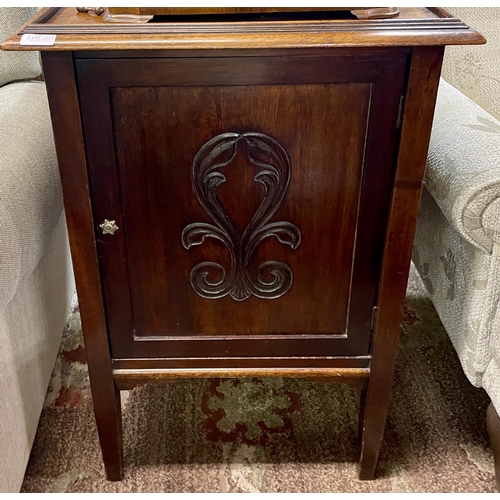 299 - A SQUARE OAK ART NOUVEAU STYLE CABINET ON RAISED LEGS WITH CARVED SINGLE DOOR AND GALLERIED TOP