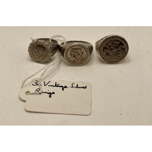 379 - THREE VINTAGE SILVER RING  - TWO BASKET RINGS WITH ST GEORGE COINS THE THIRD A SILVER BASKET SHANK W... 