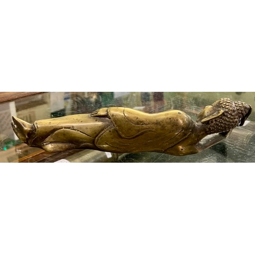 386 - AN ANTIQUE BURMESE POLISHED BRONZE FIGURE OF THE RECLINING BUDDHA, 23CM WIDE.