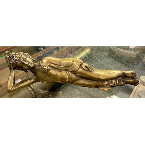 386 - AN ANTIQUE BURMESE POLISHED BRONZE FIGURE OF THE RECLINING BUDDHA, 23CM WIDE.