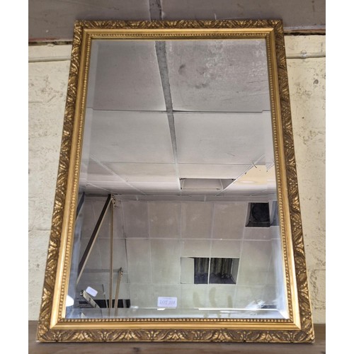 334 - LARGE RECTANGULAR GILT FRAMED WALL MIRROR WITH BEVELLED EDGES AND CARVED FRAME