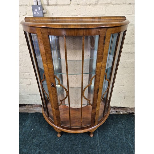 314 - AN OVAL DEMI LUNE WALNUT GLAZED DISPLAY CABINET WITH SHAPED GLASS SHELVES - ON QUEEN ANNE LEGS WITH ... 