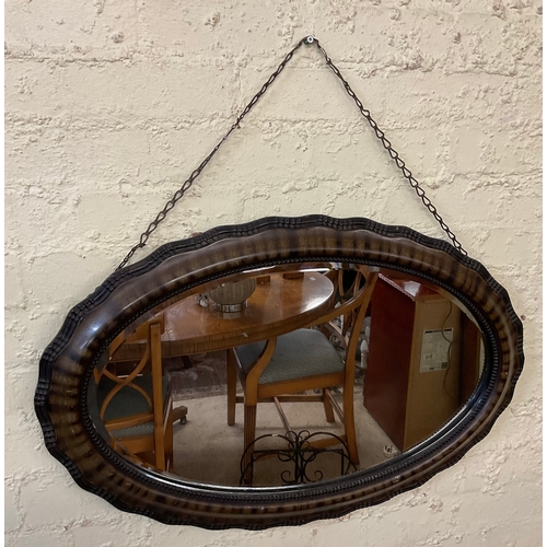 416 - AN ANTIQUE EDWARDIAN OVAL SHAPED WALL MIRROR ON CHAIN, TORTOISE SHELL EFFECT WITH STUDDED TRIM TO MI... 