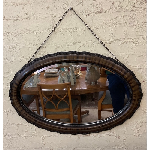 416 - AN ANTIQUE EDWARDIAN OVAL SHAPED WALL MIRROR ON CHAIN, TORTOISE SHELL EFFECT WITH STUDDED TRIM TO MI... 