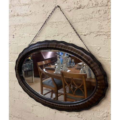 416 - AN ANTIQUE EDWARDIAN OVAL SHAPED WALL MIRROR ON CHAIN, TORTOISE SHELL EFFECT WITH STUDDED TRIM TO MI... 