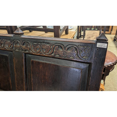 283 - AN ANTIQUE OAK VICTORIAN CARVED BENCH, IN THE JACOBEAN REVIVAL STYLE, HIGH PANELLED BACK WITH HEAVIL... 