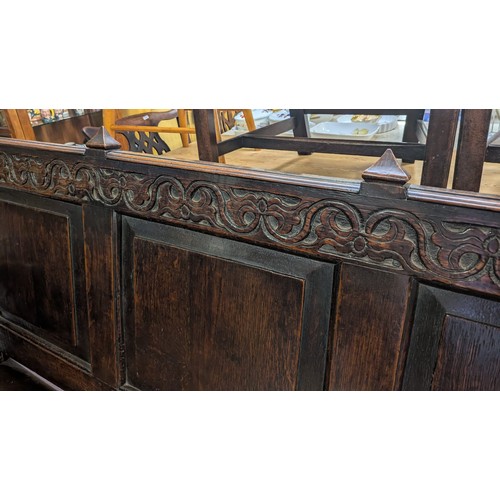 283 - AN ANTIQUE OAK VICTORIAN CARVED BENCH, IN THE JACOBEAN REVIVAL STYLE, HIGH PANELLED BACK WITH HEAVIL... 
