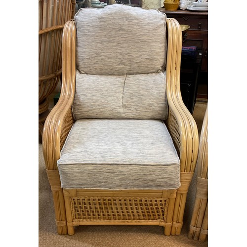 285 - A YELLOW CANE CONSERVATORY SUITE, CONSISTING OF TWO ARMCHAIRS AND A TWO SEATER SOFA, WITH UPHOLSTERE... 