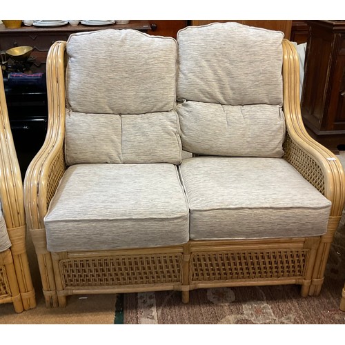 285 - A YELLOW CANE CONSERVATORY SUITE, CONSISTING OF TWO ARMCHAIRS AND A TWO SEATER SOFA, WITH UPHOLSTERE... 