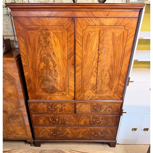 238 - A GEORGIAN MAHOGANY LINEN PRESS, A MOULDED CORNICE OVER TWO PANELLED DOORS OPENING TO SHELVED AND DR... 