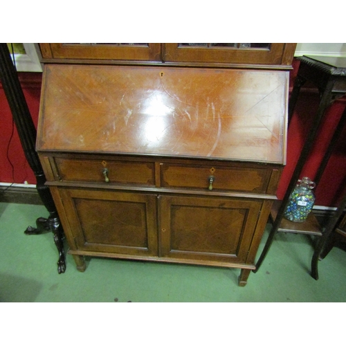 45 - A 1930's mahogany bureau bookcase, the dentil inlaid top over astragal glazing to a fall front, twin... 