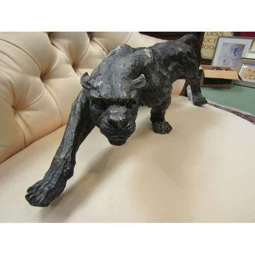 77 - A bronzed effect figure of a prowling panther, 52cm long