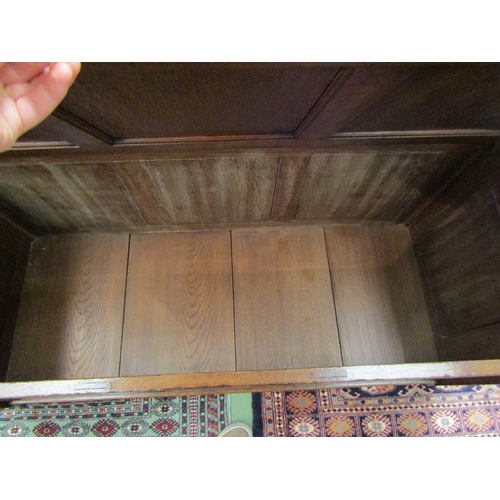 111 - An 18th Century style three panel oak coffer in the manner of 'Titchmarsh & Goodwin' the hinged top ... 