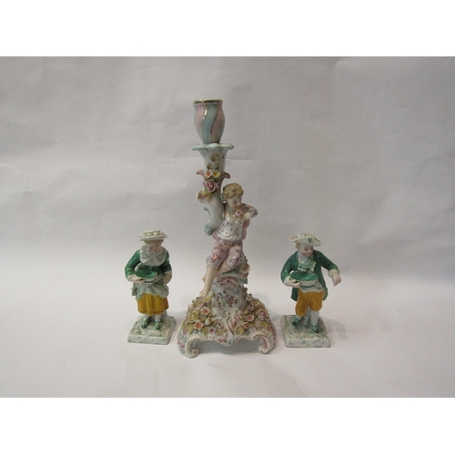 252 - A German porcelain figural candlestick, floral encrusted, boy smelling flower, crossed mark to base.... 