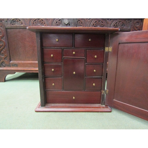 113 - A mahogany collector's cabinet, door opens to reveal eleven miniature internal drawers. 34.5cm x 34.... 