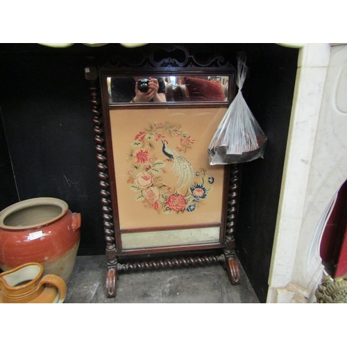 22 - A Circa 1840 mahogany fire screen. Berlin work embroidery centre panel depicting peacock, flanked by... 