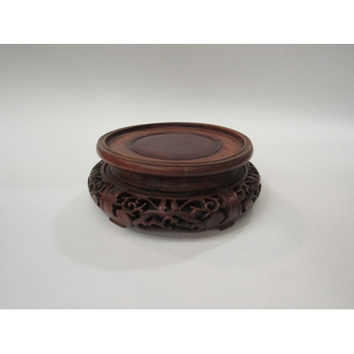 295 - A 19th Century Chinese carved rosewood display stand for a vase. 20cm diameter