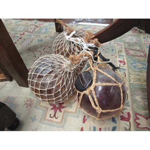 12 - Three netted glass fishing floats