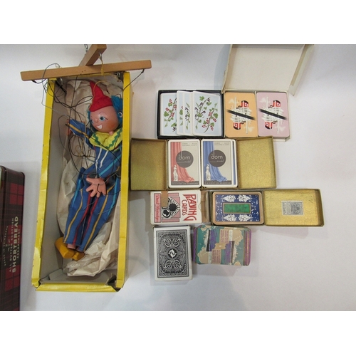 313 - A tin containing boxes of vintage playing cards together with a boxed Pelham puppet, 'clown'