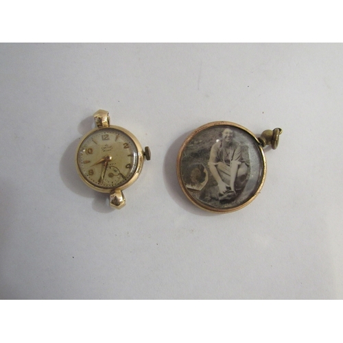 352 - A 9ct gold lady's watch face and a yellow metal surround pendant