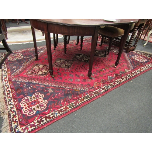 1539 - A red ground machine woven wool, geometric design rug with tasselled end, 265cm x 180cm