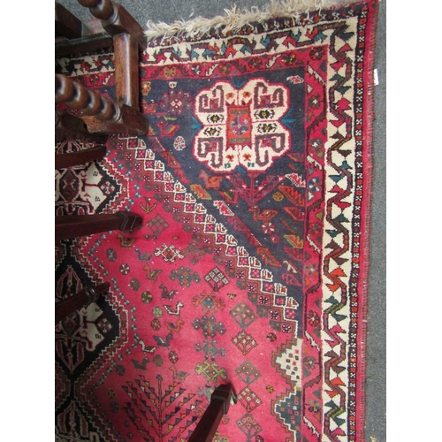 1539 - A red ground machine woven wool, geometric design rug with tasselled end, 265cm x 180cm