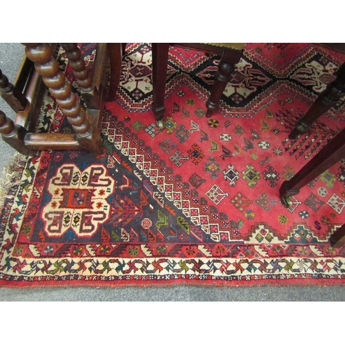 1539 - A red ground machine woven wool, geometric design rug with tasselled end, 265cm x 180cm