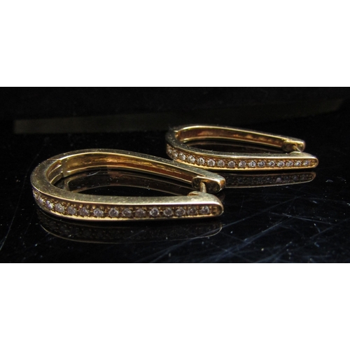 5080 - A pair of gold long hoop hinged earrings set with a graduating line of diamond to centre front, stam... 