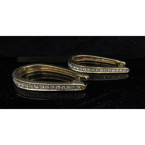 5080 - A pair of gold long hoop hinged earrings set with a graduating line of diamond to centre front, stam... 