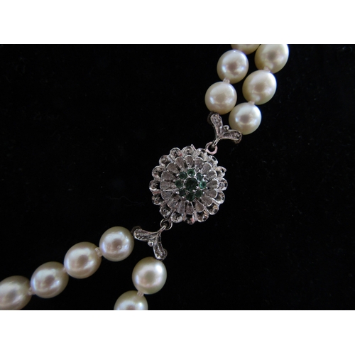 5088 - A double strand pearl necklace, 6mm pearls, 60cm long with an 18ct white gold emerald set clasp