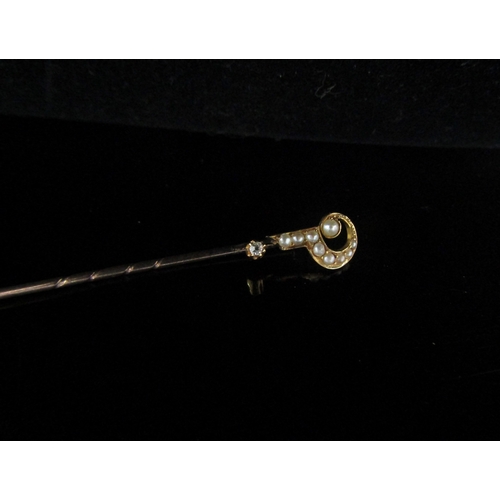 5091 - A gold stick pin stamped 18 with a seed pearl and diamond set question mark finial, 1.3g