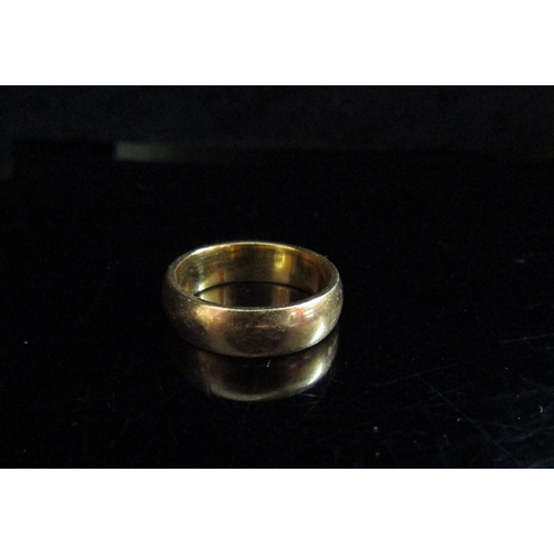 5093 - A 22ct gold wedding band. Size M, 7.4g