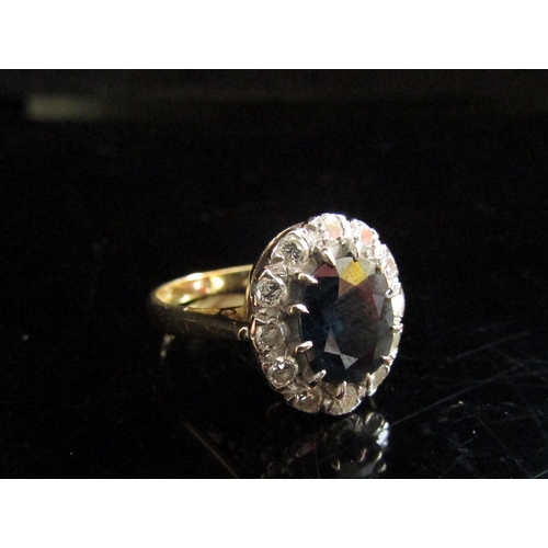 5094 - An 18ct gold sapphire and diamond cluster ring, the central oval sapphire, 10mm x 8mm framed by 12 0... 