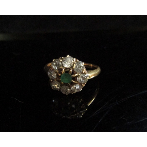 5102 - A gold ring, centrally set with an emerald framed by diamonds, stamped 18ct. Size O, 3.5g   (R) £300