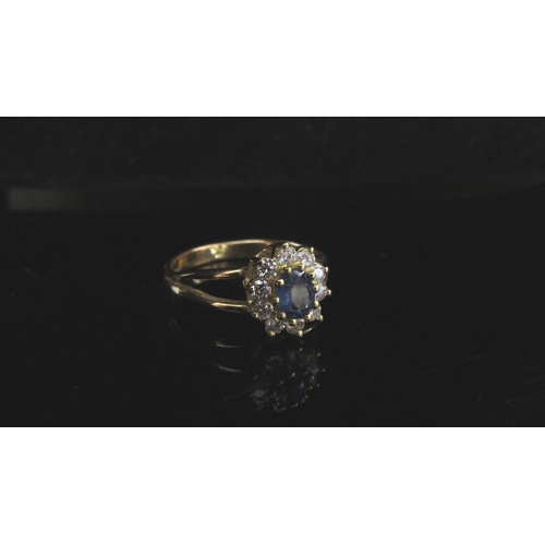 5105 - A 14ct gold ring, central oval sapphire framed by diamonds, open shoulders. Size P, 3.3g