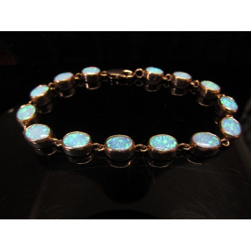 5113 - An opal bracelet, with fourteen oval opal links, stamped 375, 19cm long, 11.8g