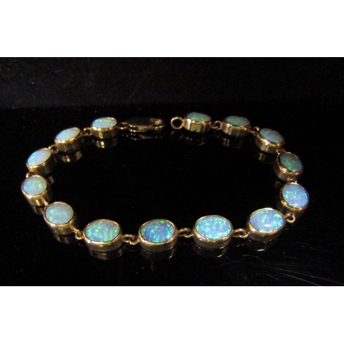 5113 - An opal bracelet, with fourteen oval opal links, stamped 375, 19cm long, 11.8g