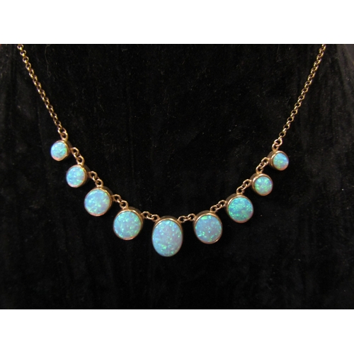 5114 - A 9ct gold necklace with nine graduated oval opal drops, 44cm long, 10.7g