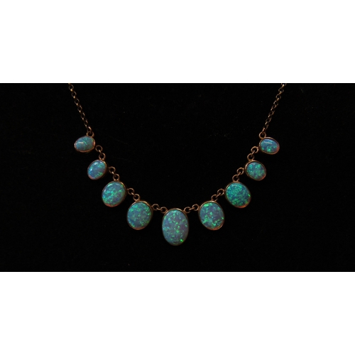 5114 - A 9ct gold necklace with nine graduated oval opal drops, 44cm long, 10.7g