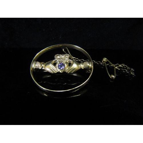 5156 - A gold brooch with hands clasping an amethyst set heart and crown, stamped 9ct, 3.7g