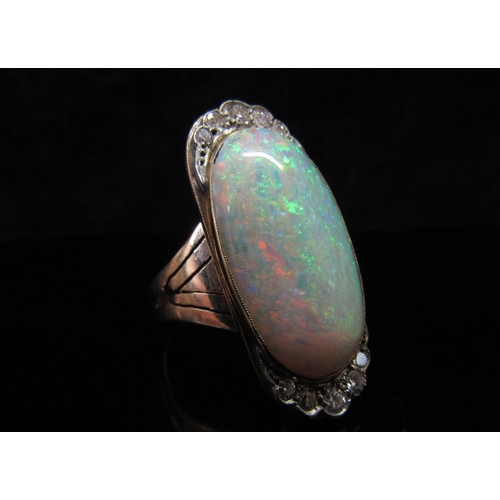 5186 - An opal and diamond ring, the central oval cabochon opal 23mm x 12.4mm x 5.77mm, estimated weight 9.... 