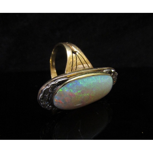 5186 - An opal and diamond ring, the central oval cabochon opal 23mm x 12.4mm x 5.77mm, estimated weight 9.... 