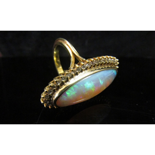 5187 - An opal and diamond ring the central oval opal 26.9mm x 10.4mm x 5.4mm, estimated weight 8.87ct fram... 