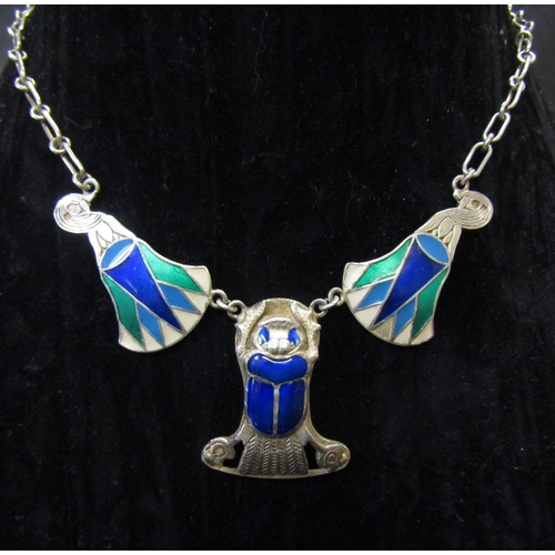 5128 - An Egyptian revival silver and enamel necklace featuring a large scarab beetle flanked by two lotus ... 