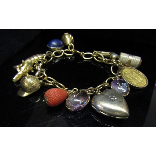 5142 - A 9ct gold charm bracelet hung with 9ct gold charms including articulated fish, crocodile, jockey ha... 