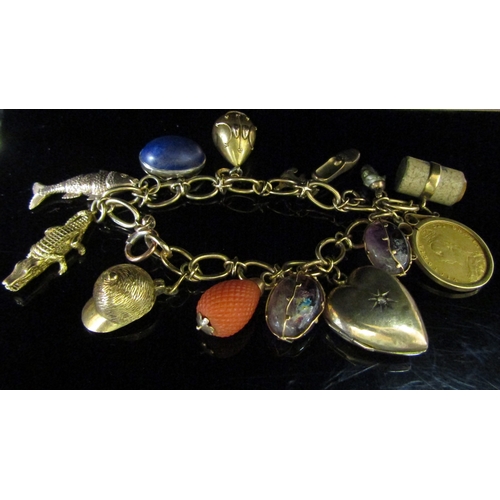 5142 - A 9ct gold charm bracelet hung with 9ct gold charms including articulated fish, crocodile, jockey ha... 